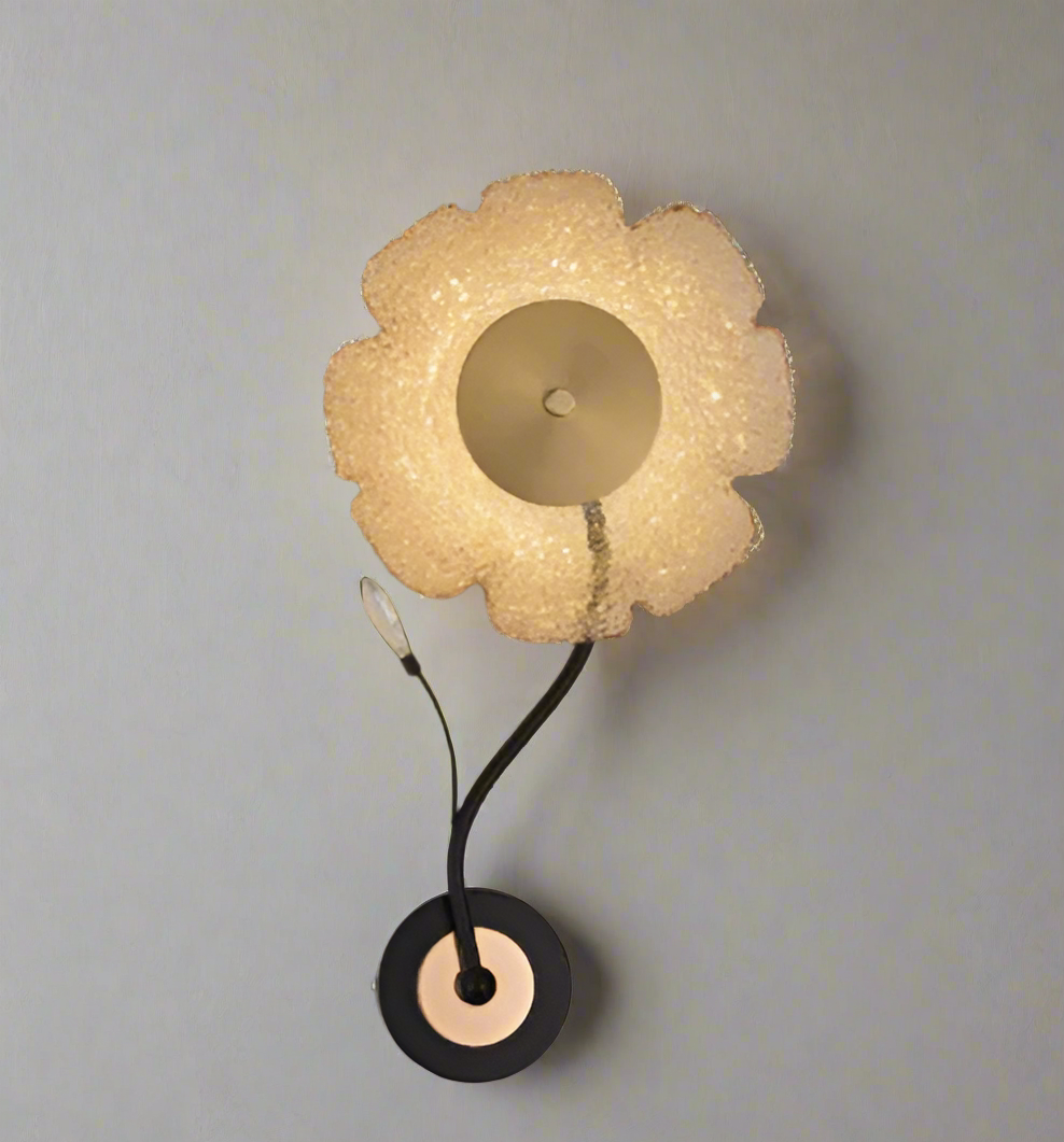 Decorative wall lamp with a floral design on a dark wall.